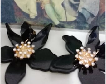Clips de orejas de flores negras (probablemente orquídeas) hechos de plástico