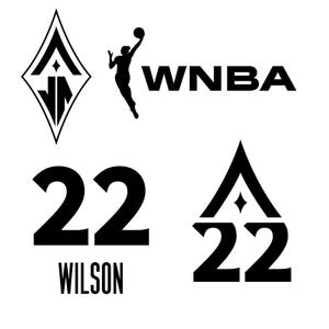 Puede incluir: Gráfico en blanco y negro con el logo de la WNBA, una silueta de jugadora de baloncesto y el número 22 con el nombre WILSON. Incluye un logotipo en forma de diamante y un número 22 estilizado.