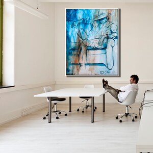 Puede incluir: Una gran pintura abstracta de una persona con un sombrero sentada en un sof&aacute;. La pintura est&aacute; en tonos de azul, blanco y marr&oacute;n. La pintura est&aacute; colgada en una pared blanca en una oficina moderna.