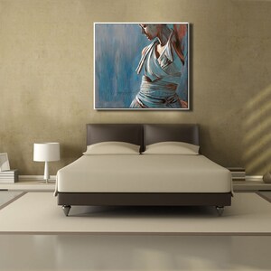 May include: A bedroom interior with a bed, a lamp, and a painting of a woman in a white dress. The painting is on the wall above the bed.