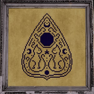 May include: A framed cross-stitch design of a blue and gold Ouija board planchette on a beige background. The frame is surrounded by a row of lit candles.