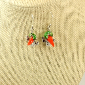 May include: A pair of silver dangle earrings with a green cactus and red chili pepper charm.