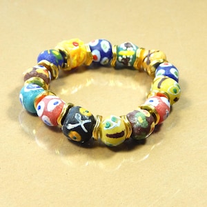 May include: A colorful beaded bracelet with a variety of patterned beads in shades of blue, yellow, red, and green. The beads are strung together with gold-colored metal accents, creating a vibrant and eye-catching accessory.