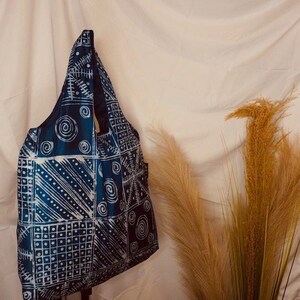 May include: A blue and white tote bag with a patchwork design. The bag is made of fabric and has a simple, casual style.