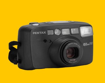 Câmera analógica vintage Pentax IQZoom 140 de filme 35 mm, compacta e fácil de usar, com lente zoom de 38-140 mm, ideal para fotógrafos retrô.