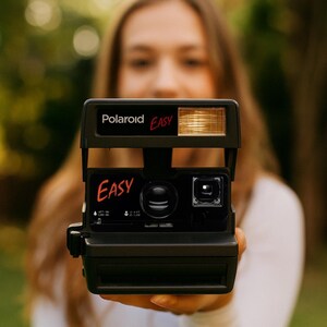 Ajoutez facilement votre texte grâce à Polaroid : appareil photo argentique 600, flash intégré, capacité de gros plan, testé et prêt à photographier