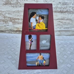 May include: A burgundy-colored multi-photo frame with three rectangular openings and one square opening. The frame holds family photos of a mother and daughter, a child at the beach, and a father with two children and a dog. The frame has a unique angled design.