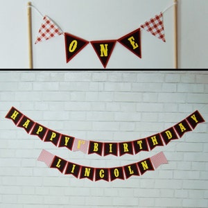 May include: Red and black bunting with yellow letters spelling "Happy 1st Birthday Lincoln" with red and white gingham flags in between.