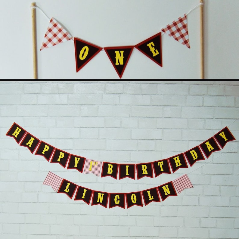May include: Red and black bunting with yellow letters spelling "Happy 1st Birthday Lincoln" with red and white gingham flags in between.