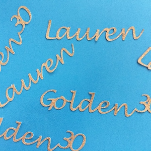 May include: Gold glitter letters spelling "Golden 30" and "Lauren" on a blue background.