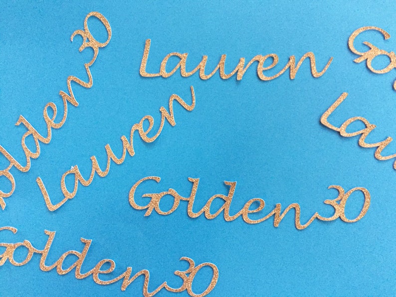May include: Gold glitter letters spelling "Golden 30" and "Lauren" on a blue background.