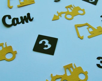 May include: A collection of yellow construction vehicle cutouts, black numbers, and the name "Cam" in black letters. The cutouts are on a white background.