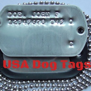 May include: Two silver military dog tags with a black chain. The top tag has the text "DOE, JOHN F 12345678 143 0" engraved on it. The bottom tag has the text "USA Dog Tags" printed on it.