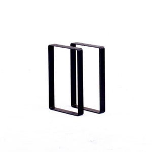 Peut inclure: Deux pieds de table en m&eacute;tal noir, chacun avec un cadre rectangulaire.