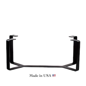 May include: A black metal table base featuring a wide, flat, Y-shaped frame with four vertical supports and horizontal mounting plates at the top. The text "Made in USA" is printed below the base, accompanied by a small American flag icon.
