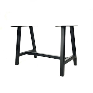 May include: Black metal table base with a modern design. The base features two A-frame legs connected by a horizontal bar. The top of the legs have a flat surface for attaching a tabletop. The base is suitable for a dining table or desk.