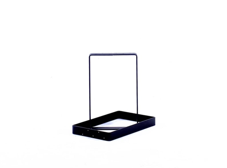 Peut inclure: Un support en m&eacute;tal noir avec une base rectangulaire et un cadre carr&eacute;. Le support est con&ccedil;u pour tenir des objets comme des plantes ou d'autres objets d&eacute;coratifs.