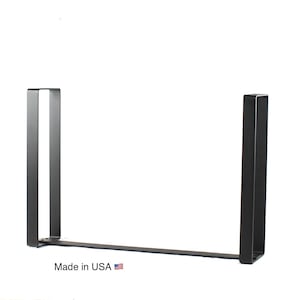 May include: Black metal table legs in a U-shape design. The legs are made of square tubing and are connected by a flat bar. The text "Made in USA" is printed on the bottom.