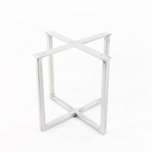May include: Silver metal table base with a square shape and a cross-shaped support in the center.