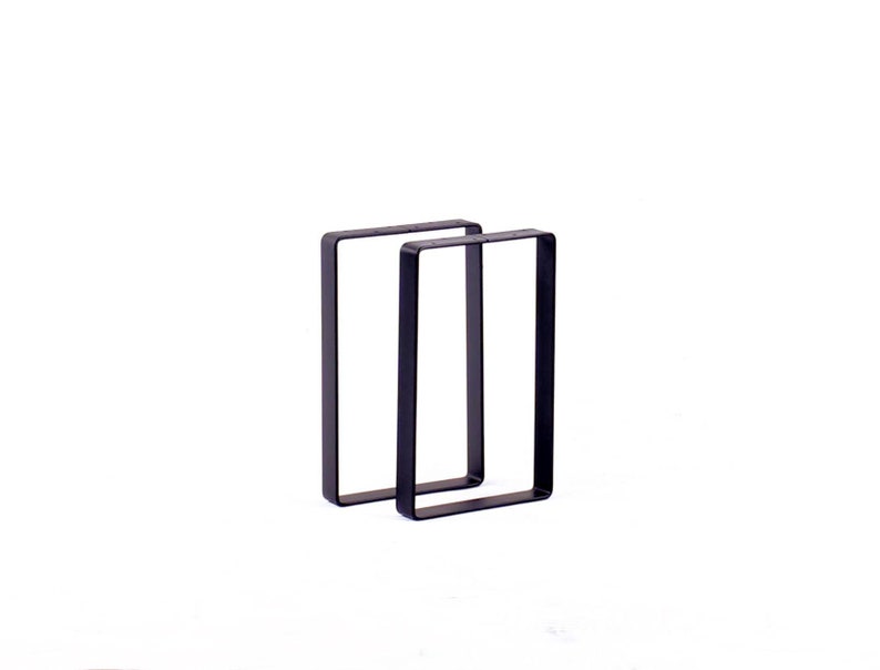 Peut inclure: Deux pieds de table en m&eacute;tal noir de forme rectangulaire.
