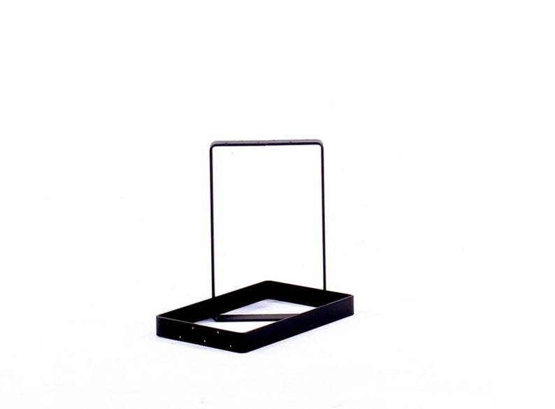 Peut inclure: Un support en m&eacute;tal noir avec une base rectangulaire et un cadre vertical. Le support est con&ccedil;u pour tenir des objets.