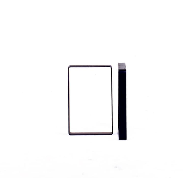 Peut inclure: Deux pieds de table en m&eacute;tal noir, l'un est un cadre carr&eacute; et l'autre est une seule pi&egrave;ce rectangulaire.