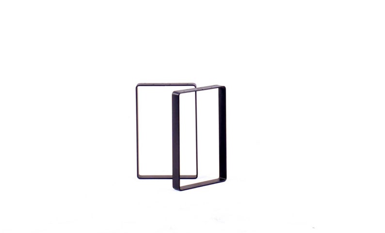Peut inclure: Deux pieds de table en m&eacute;tal noir, chacun avec un cadre rectangulaire.