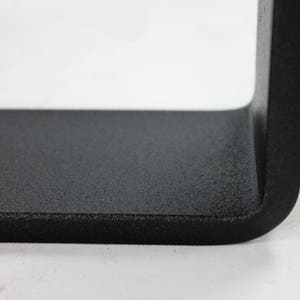 Peut inclure: Gros plan sur un cadre en m&eacute;tal noir avec une finition textur&eacute;e. Le cadre est pli&eacute; &agrave; un angle de 90 degr&eacute;s, cr&eacute;ant un bord tranchant.