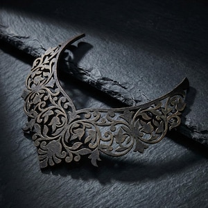 May include: Laser cut necklace template with intricate floral and leaf patterns. The dark brown design is set against a dark background. The text "Laser Cut Necklace Template" is at the top.