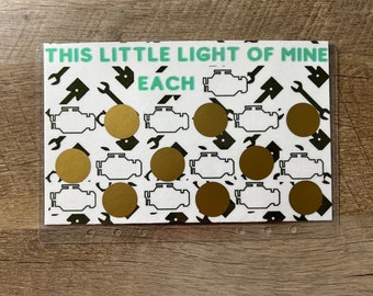 Puede incluir: Una tarjeta blanca con el texto "This Little Light of Mine" y "Each" impreso en verde. La tarjeta tiene un patrón de símbolos de llave inglesa y motor negros. Hay 10 círculos dorados en la tarjeta.