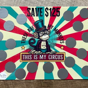 May include: A colorful card with a cartoon monkey wearing a top hat and the text "These are my monkeys. This is my circus."  There are 15 silver scratch-off circles on the card. The text "Save $125" is at the top of the card.