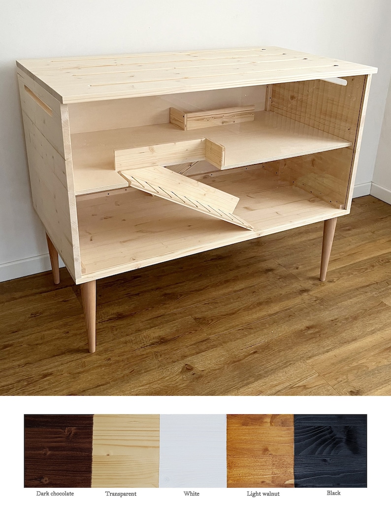 May include: A wooden pet cage with a ramp and a shelf. The cage is made of natural wood and has a light wood finish. The cage is on four legs and has a modern design.