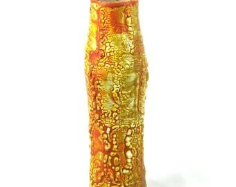 May include: A tall, textured ceramic vase with a cylindrical shape. The vase features a mottled surface with shades of yellow, orange, and red. The interior of the vase is a darker orange color. The vase is standing upright against a white background.