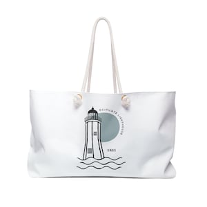 Op de afbeelding: Witte canvas tote bag met een zwart-witte illustratie van een vuurtoren en de tekst "Scituate Lighthouse 1811".