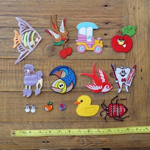 以下が含まれることがあります： 魚、鳥、車、リンゴ、歯、虫、アヒル、プードル、ボールなど、さまざまなデザインが施された、カラフルな刺繍のアイロン接着パッチ13個のセットです。