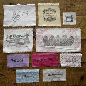 May include: Assortment of fabric scraps with various sewing-themed words and images, including "J & P Coats", "Haberdashery", "Buttons", "Needle Book", "Lace", "Sewing", and "Handmade".