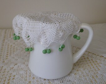 Vintage white crocheted jug cover with green glass beads