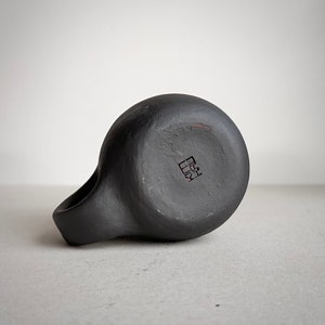 May include: Black ceramic mug with a handle and a square mark on the bottom that reads "陶芸".