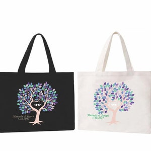 May include: Two tote bags, one black and one white, each featuring a tree design with a heart-shaped swing and two birds. The tree has purple, blue, and green leaves. The text "Manuela & Steven 5-10-2017" is printed below.