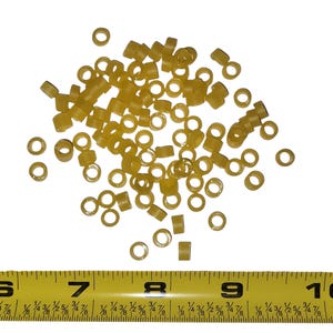 May include: A pile of small, translucent yellow rubber O-rings and cylindrical spacers. A yellow measuring tape is at the bottom of the image, showing measurements in inches.