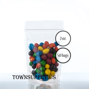 May include: A clear plastic stand-up pouch with a zipper closure filled with colorful candy. The pouch is labeled "2 oz." and "50 bags".
