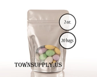 May include: A silver stand-up pouch containing pastel-colored candy-coated almonds, featuring a clear circular window. The pouch is labeled 2 oz. and 20 bags, with the text TOWNSUPPLY.US printed in black at the bottom of the packaging.