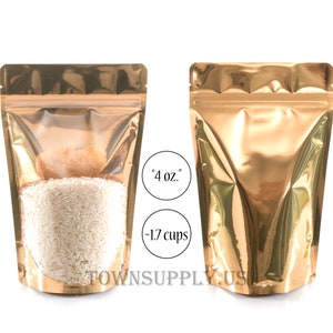 May include: Two gold stand-up pouches with a zipper closure. The pouch on the left is filled with white rice and has a clear window. The pouch on the right is empty. The text "4 oz." and "-1.7 cups" is printed on the image.
