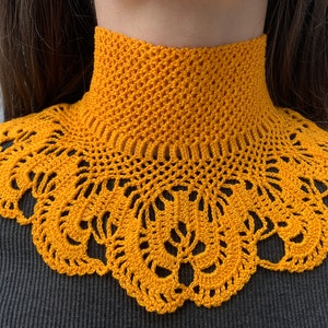 Puede incluir: Un collar de ganchillo amarillo con un delicado patr&oacute;n de encaje. El collar est&aacute; hecho de un hilo suave y ligero y es perfecto para agregar un toque de estilo vintage a cualquier atuendo.