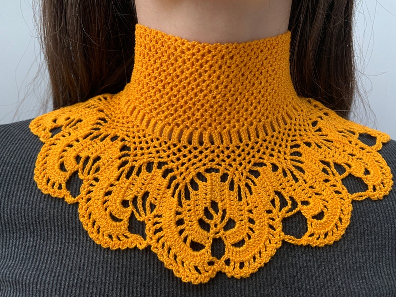 Puede incluir: Un collar de ganchillo amarillo con un delicado patr&oacute;n de encaje. El collar est&aacute; hecho de un hilo suave y ligero y es perfecto para agregar un toque de estilo vintage a cualquier atuendo.