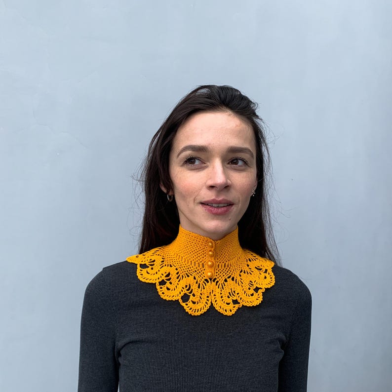 Puede incluir: Un collar de crochet amarillo con cierre de bot&oacute;n. El collar est&aacute; hecho de encaje delicado y tiene un borde festoneado.