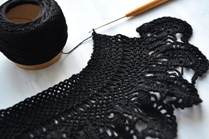 May include: Black crochet lace edging with a ball of black yarn and a crochet hook.