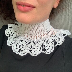 Puede incluir: Collar de encaje blanco tejido a crochet con borde festoneado.