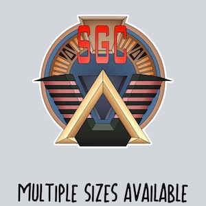 May include: A sticker featuring a stylized emblem with the letters "SGC" in red. The design includes a gold triangle, blue and brown circular elements, and the text "MULTIPLE SIZES AVAILABLE" at the bottom.