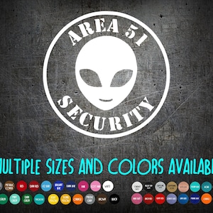 May include: White Area 51 Security alien head sticker on a dark gray textured background. The design is in a circular shape with the text "AREA 51 SECURITY". The text "MULTIPLE SIZES AND COLORS AVAILABLE" is below the design.